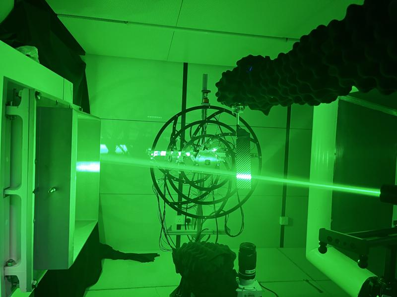 Circular microphone array under green laser illumination beside a wind-tunnel test section
